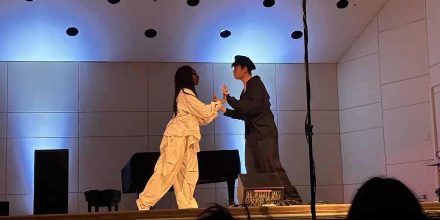 The two dancers face to face at centre stage